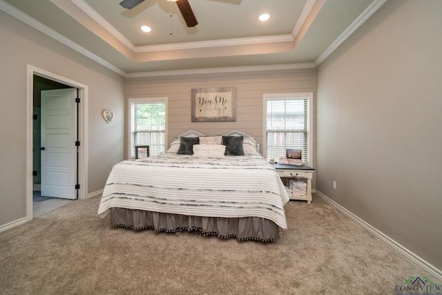 bedroom with ceiling fan, ornamental molding, a raised ceiling, and carpet floors