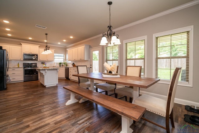 dining area with ornamental molding, dark wood-type flooring, and a chandelier