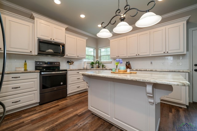 kitchen featuring stainless steel appliances, white cabinetry, a kitchen island, and pendant lighting