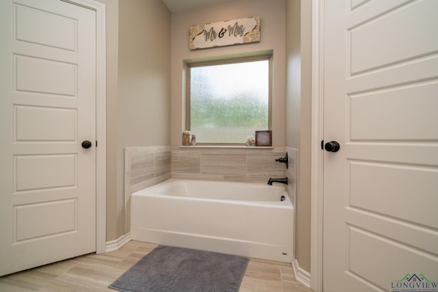 bathroom featuring wood-type flooring and a tub