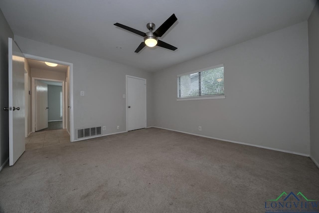 unfurnished bedroom featuring ceiling fan, light colored carpet, and a closet