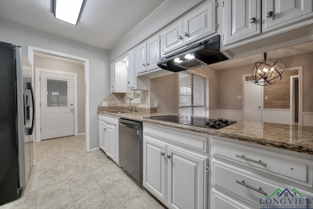 kitchen with sink, white cabinetry, stainless steel appliances, light stone counters, and a chandelier