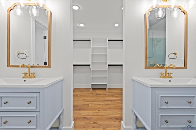 330 Forest Hls, Hallsville, TX 75650 - bathroom featuring wood finished floors, two vanities, recessed lighting, and a spacious closet