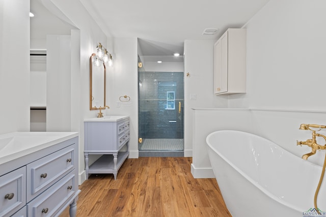 330 Forest Hls, Hallsville, TX 75650 - full bath with two vanities, a stall shower, wood finished floors, a freestanding tub, and recessed lighting