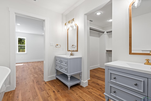 330 Forest Hls, Hallsville, TX 75650 - bathroom featuring two vanities, wood finished floors, a freestanding bath, and recessed lighting