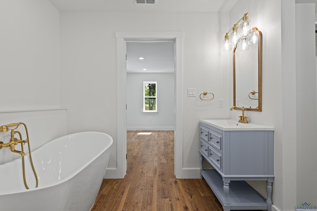 330 Forest Hls, Hallsville, TX 75650 - full bath with vanity, a soaking tub, and wood finished floors