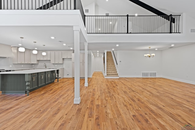 330 Forest Hls, Hallsville, TX 75650 - unfurnished living room featuring a towering ceiling, light wood-type flooring, stairs, a chandelier, and recessed lighting