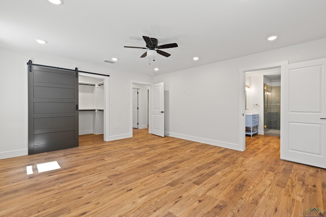 330 Forest Hls, Hallsville, TX 75650 - unfurnished bedroom with light wood-style floors, a barn door, recessed lighting, a spacious closet, and ensuite bath