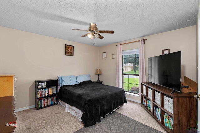 bedroom with a textured ceiling, carpet floors, and ceiling fan