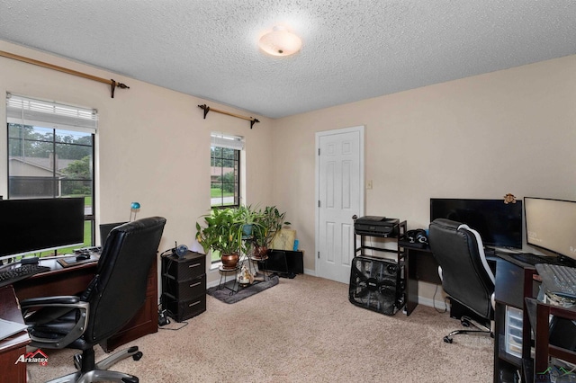 carpeted office featuring a textured ceiling