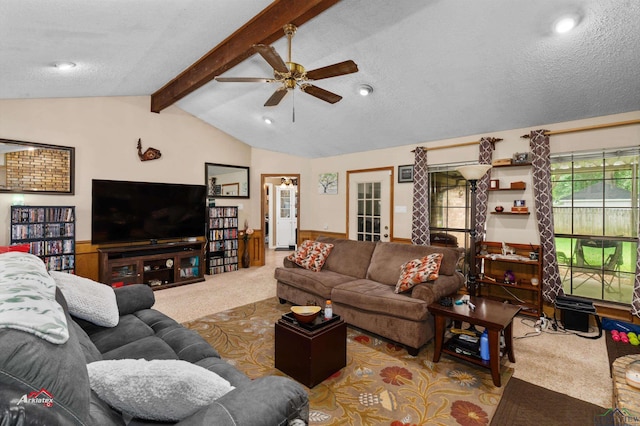 living room with a textured ceiling, vaulted ceiling with beams, ceiling fan, and light carpet