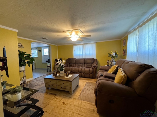 living room featuring ceiling fan, crown molding, and a textured ceiling