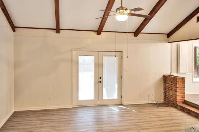 unfurnished living room with ceiling fan, french doors, vaulted ceiling with beams, and wood finished floors