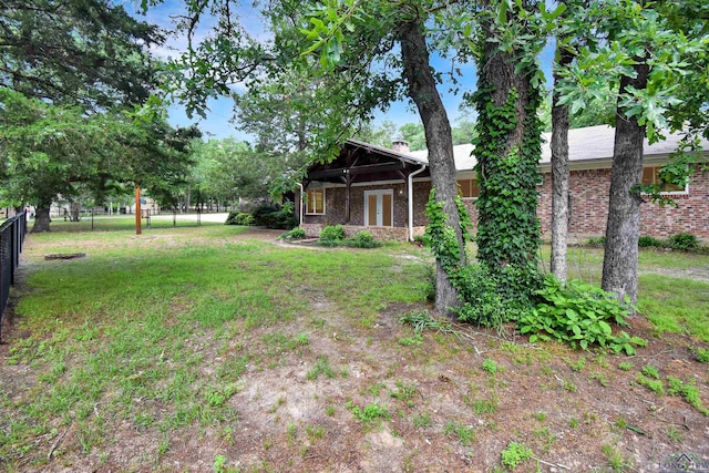 view of yard with fence and french doors