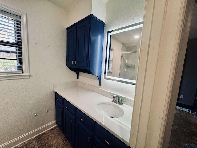 bathroom with vanity, a shower with shower door, and a wealth of natural light