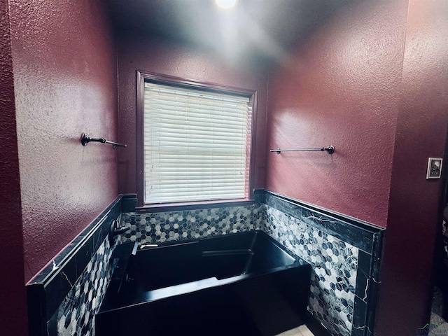 bathroom with tile walls and a bathing tub