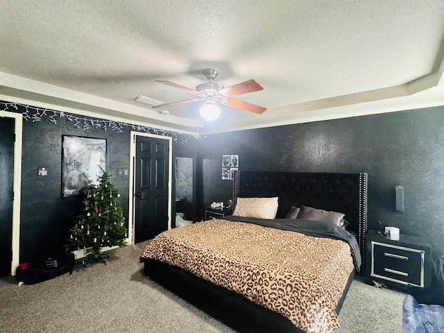 bedroom with carpet flooring, ceiling fan, and a textured ceiling