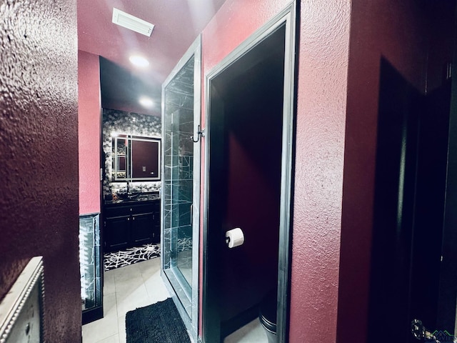 bathroom with tile patterned floors, vanity, toilet, and tiled shower