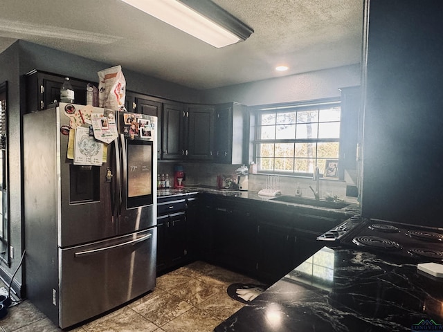 kitchen featuring stainless steel refrigerator with ice dispenser, a textured ceiling, and sink