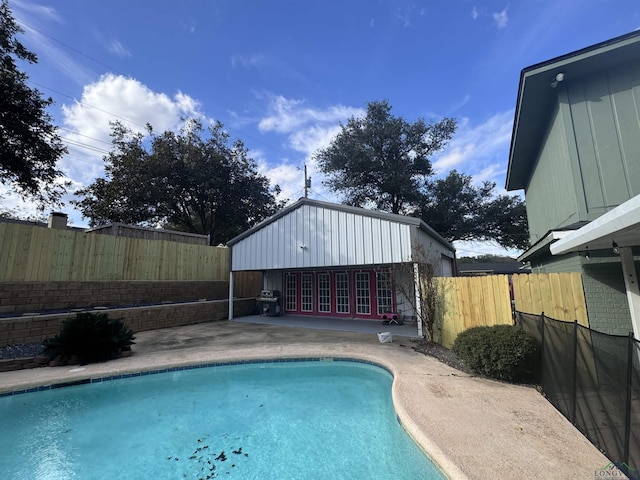 view of swimming pool featuring an outbuilding and a patio area