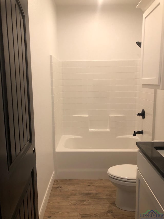 full bathroom featuring vanity, hardwood / wood-style flooring, toilet, and shower / washtub combination