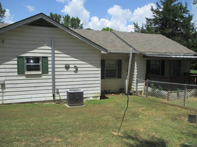 view of front of property with central air condition unit and a front yard