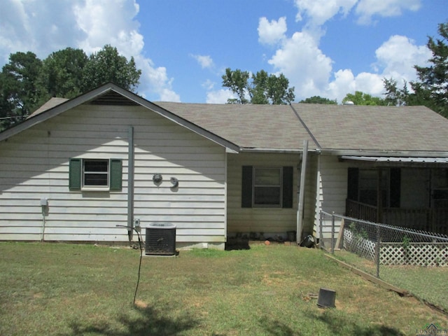 view of front of house with central AC unit and a front yard