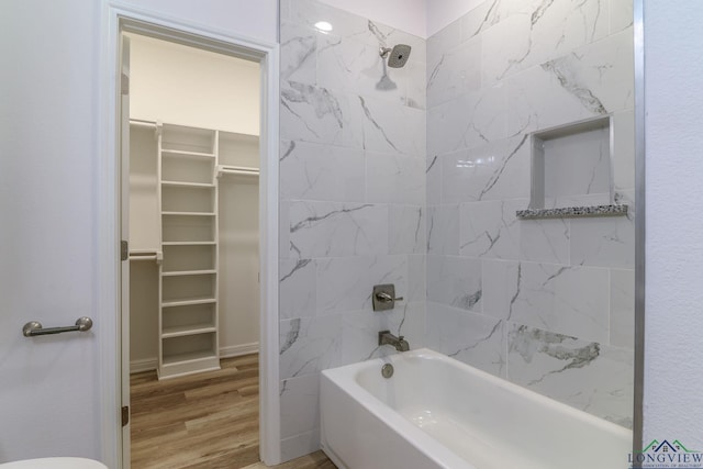 bathroom with tiled shower / bath combo and hardwood / wood-style flooring