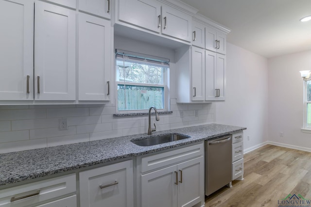 kitchen featuring dishwasher, white cabinets, sink, light hardwood / wood-style flooring, and light stone countertops