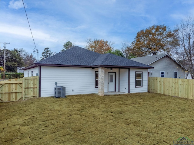 rear view of property with ceiling fan, a yard, and central AC unit