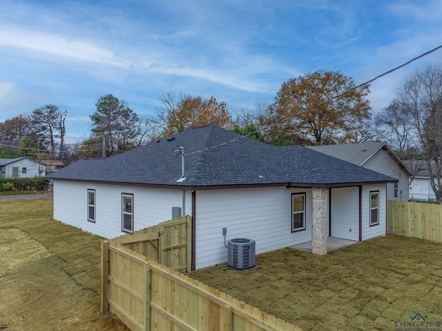 back of property featuring a lawn and central air condition unit