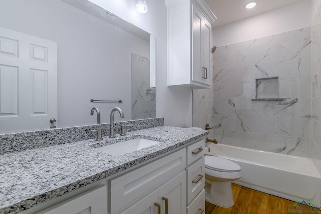 full bathroom featuring hardwood / wood-style flooring, vanity, shower / bathtub combination, and toilet