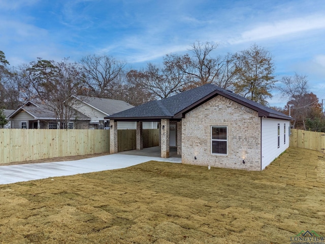 rear view of property featuring a lawn and a patio