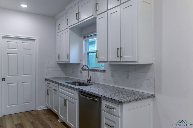 kitchen featuring backsplash, sink, stainless steel dishwasher, dark hardwood / wood-style flooring, and white cabinetry