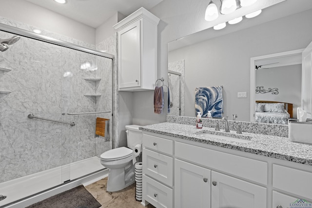 bathroom featuring ceiling fan, toilet, vanity, and walk in shower