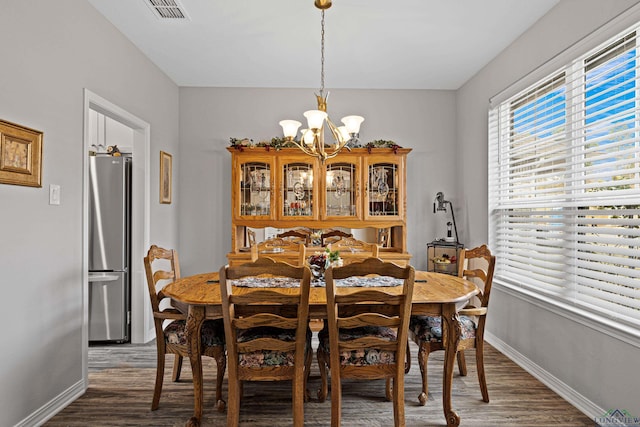 dining space with an inviting chandelier and dark wood-type flooring