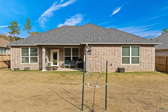 rear view of property with a yard and a patio