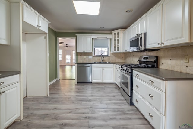 kitchen featuring ceiling fan, sink, stainless steel appliances, light hardwood / wood-style flooring, and white cabinets