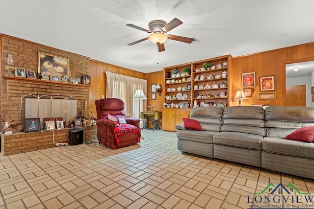 living room with ceiling fan and wood walls