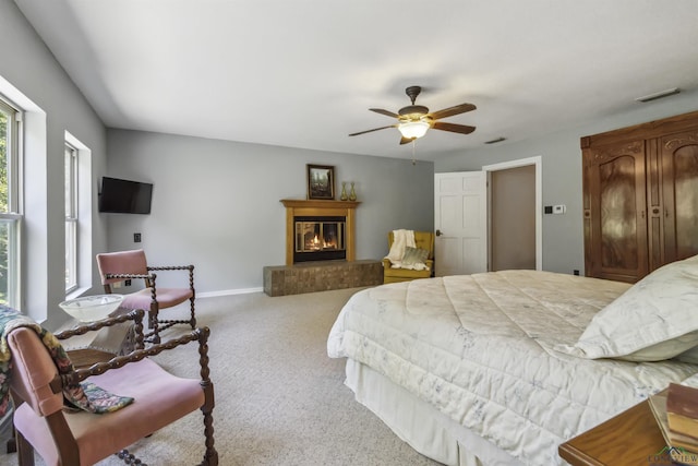 bedroom featuring light carpet, multiple windows, and ceiling fan