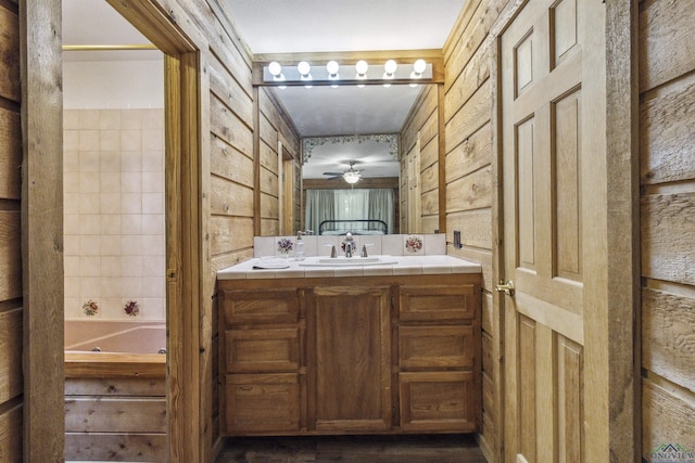 bathroom with vanity, ceiling fan, and a tub