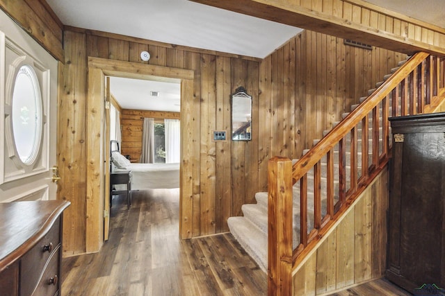 stairway with wood walls and hardwood / wood-style floors