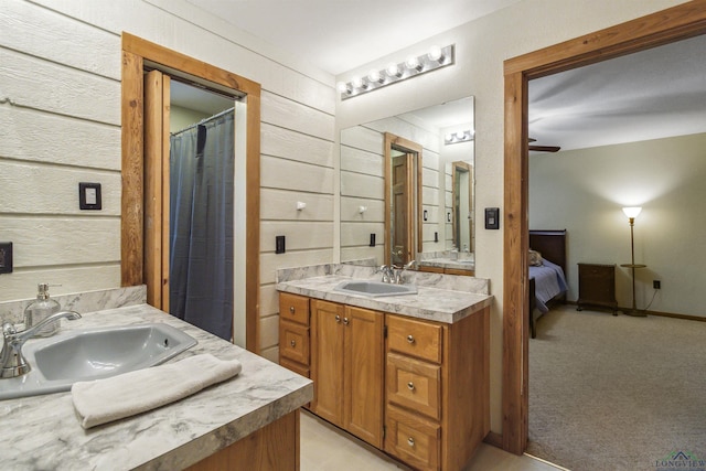 bathroom featuring wood walls, vanity, and ceiling fan