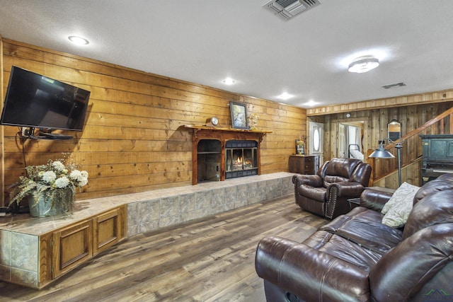 living room featuring hardwood / wood-style floors and wooden walls