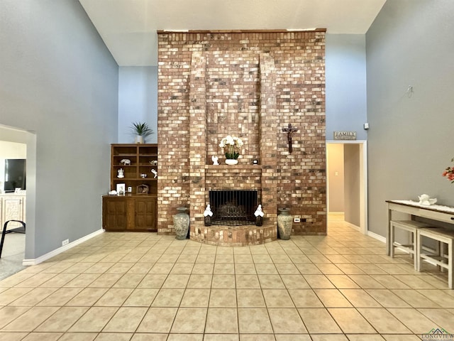 unfurnished living room featuring a brick fireplace, high vaulted ceiling, and light tile patterned floors