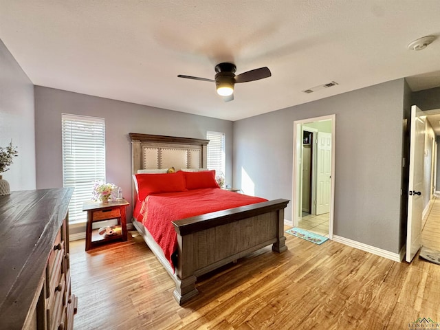 bedroom with hardwood / wood-style flooring, ceiling fan, and multiple windows