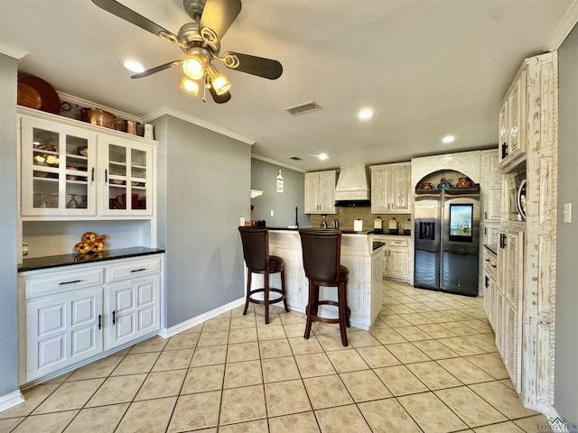 kitchen with stainless steel fridge with ice dispenser, light tile patterned floors, custom range hood, white cabinets, and ceiling fan