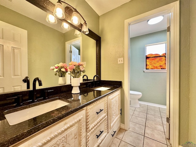 bathroom with toilet, tile patterned flooring, a notable chandelier, and vanity