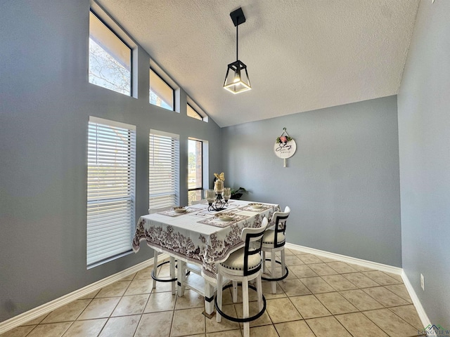 dining space with a textured ceiling, vaulted ceiling, and light tile patterned floors