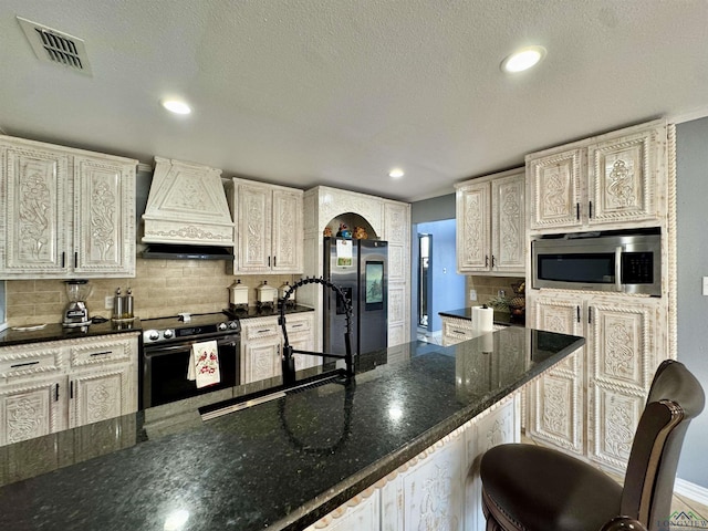 kitchen with custom exhaust hood, stainless steel appliances, a kitchen bar, sink, and backsplash